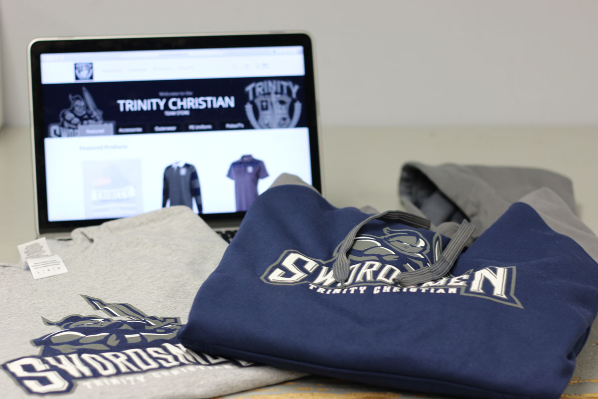 A published example of a team apparel storefront on a laptop beside decorated clothing